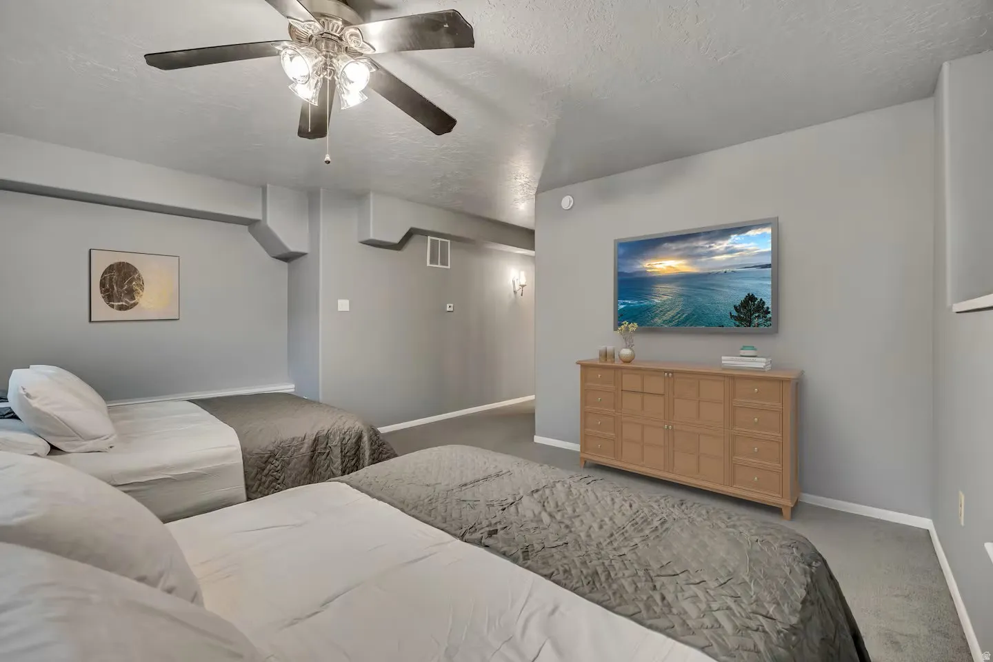 Carpeted bedroom featuring a ceiling fan and a textured ceiling