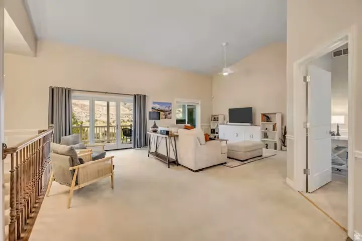 Living room featuring light colored carpet and vaulted ceiling