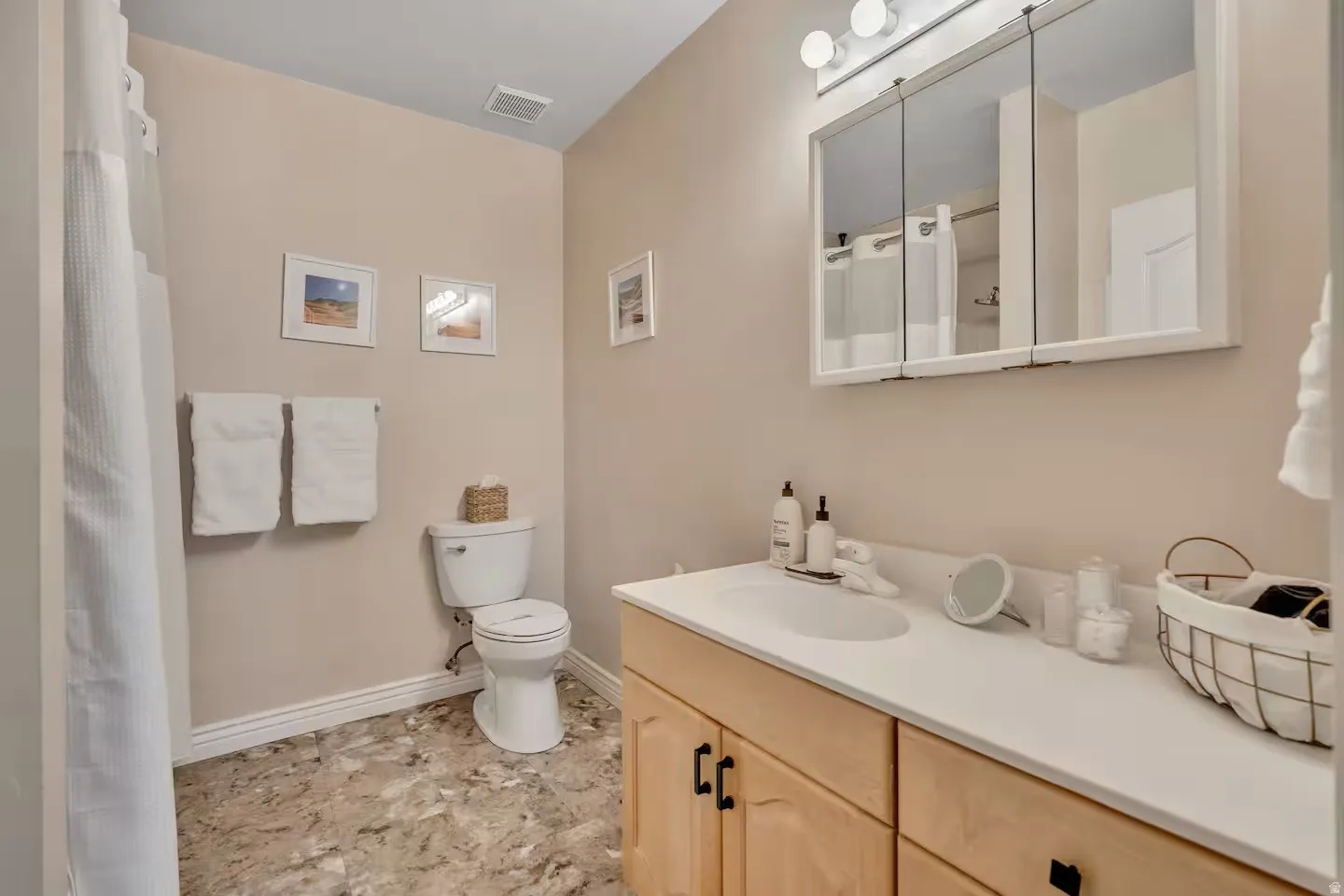Bathroom featuring curtained shower and vanity