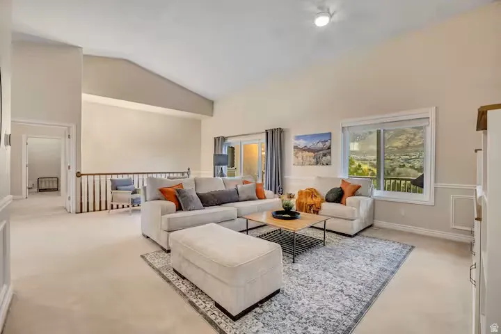 Living room with carpet flooring and lofted ceiling