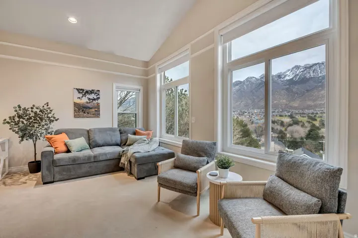 Living room with lofted ceiling, a mountain view, carpet flooring, and recessed lighting