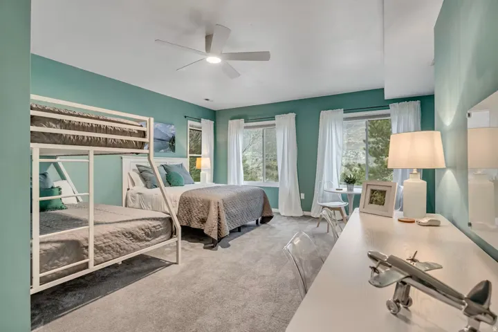 Bedroom with light colored carpet and a ceiling fan