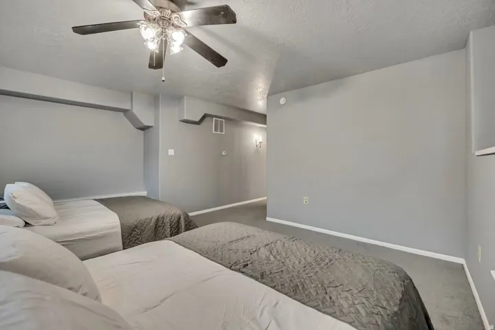 Home theater with a textured ceiling, a ceiling fan, and carpet floors