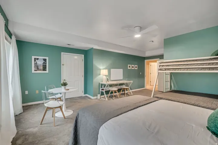 Carpeted bedroom featuring baseboards and a ceiling fan