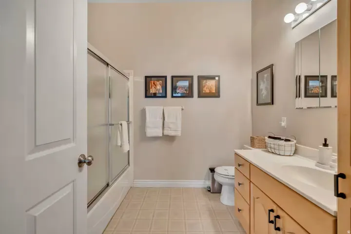 Full bath featuring vanity and bath / shower combo with glass door