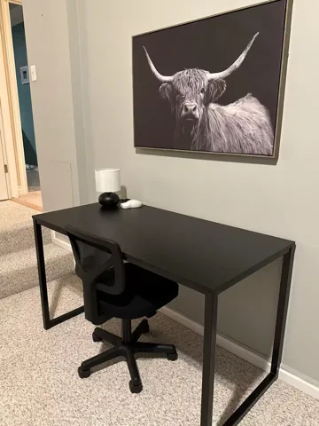 Office space with light colored carpet and baseboards