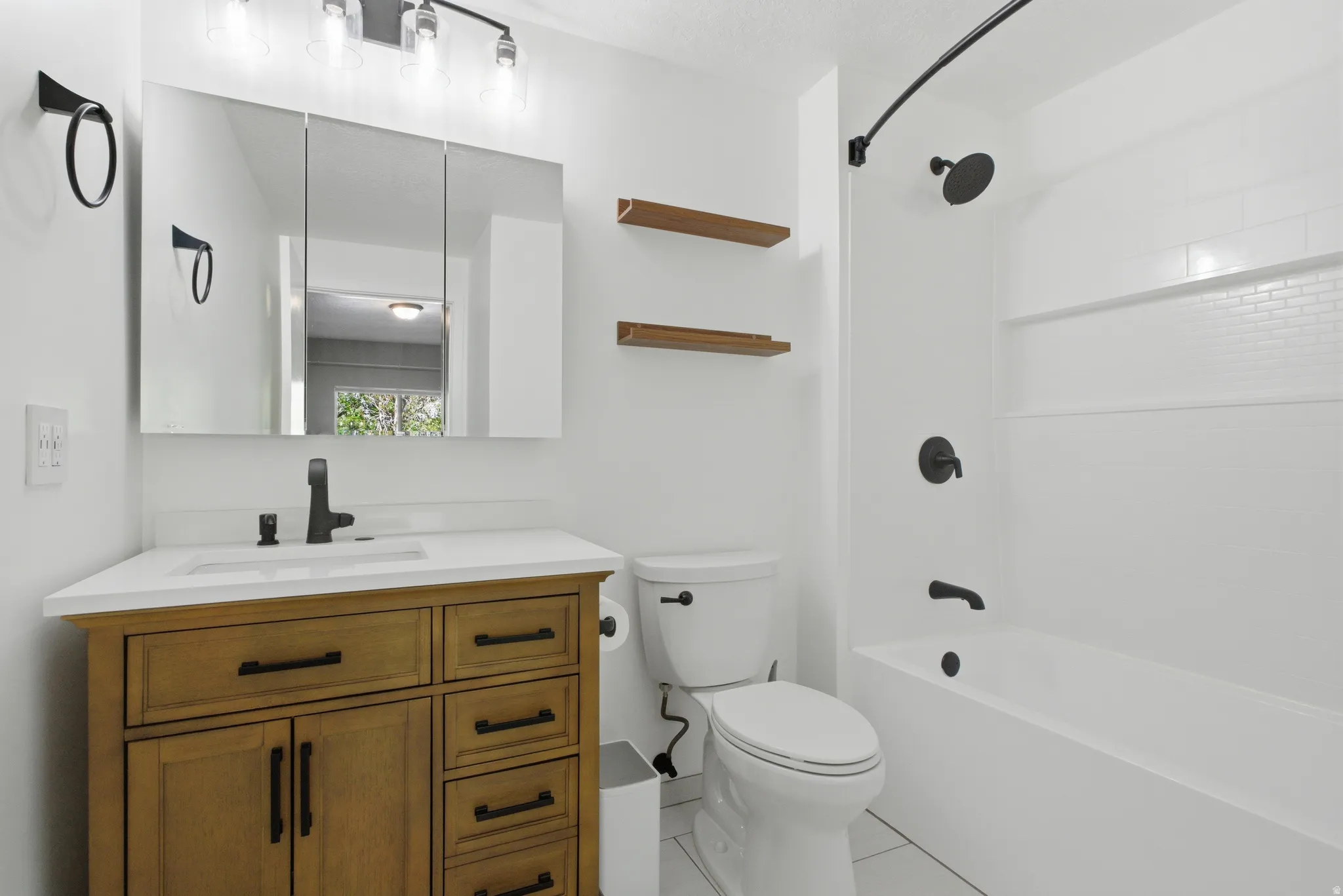 Bathroom featuring vanity, bathing tub / shower combination, and light tile patterned flooring