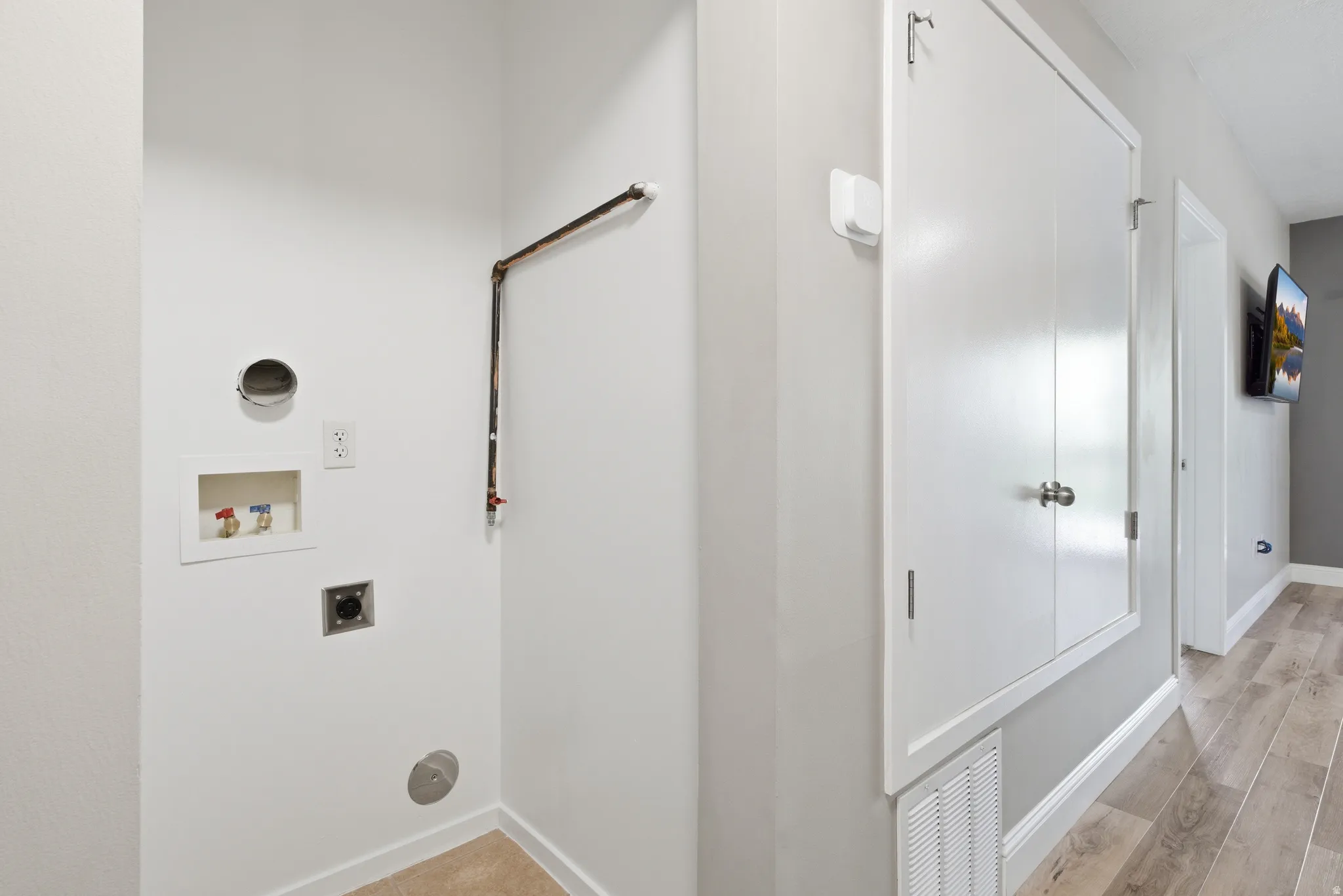 Laundry area featuring gas and electric hookup, light tile flooring, and a floor drain