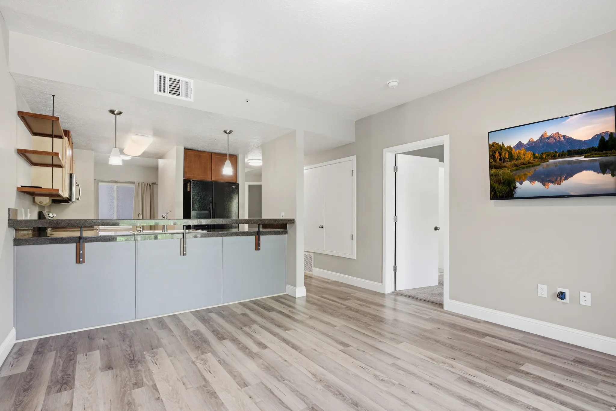 Living room whiff light wood-type flooring and baseboards