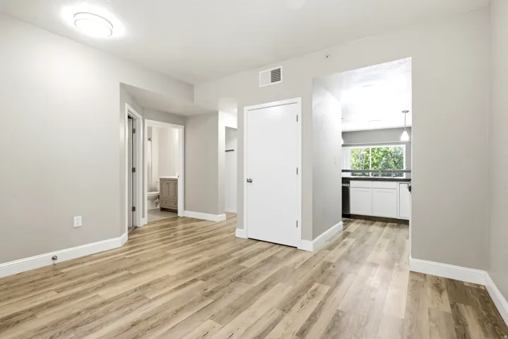 Spacious room featuring wood-finish flooring, light gray walls, and white baseboards
