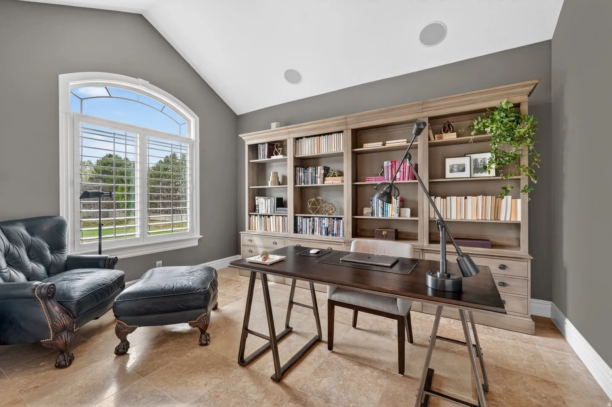Office with vaulted ceiling and baseboards