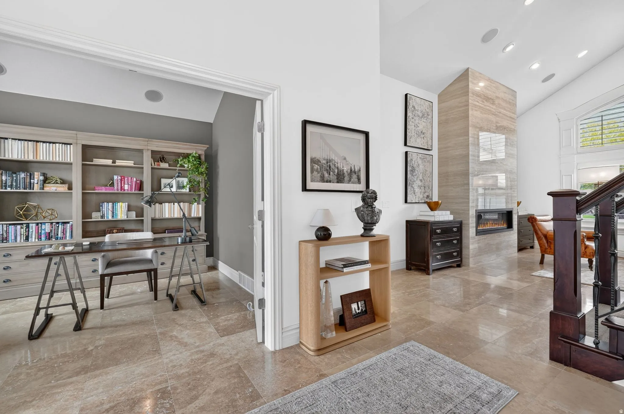 Office space with a tile fireplace and a high ceiling