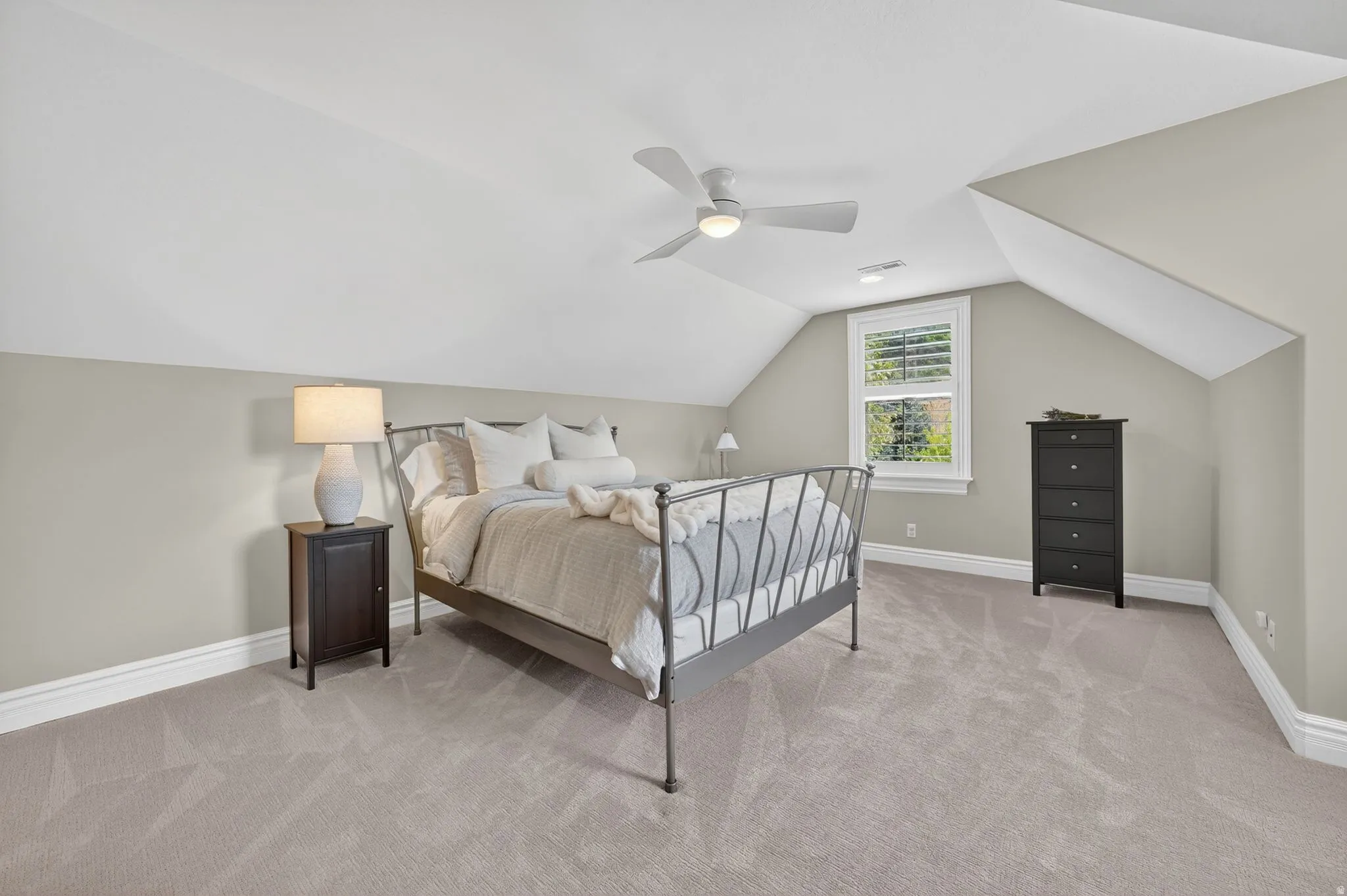 Bedroom featuring light carpet, vaulted ceiling, and ceiling fan