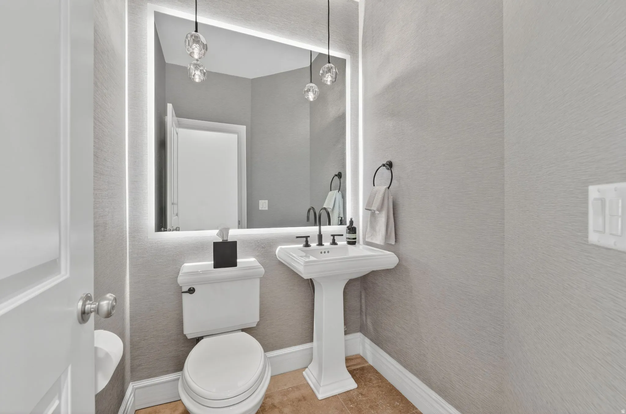 Bathroom with light tile patterned floors and a textured wall
