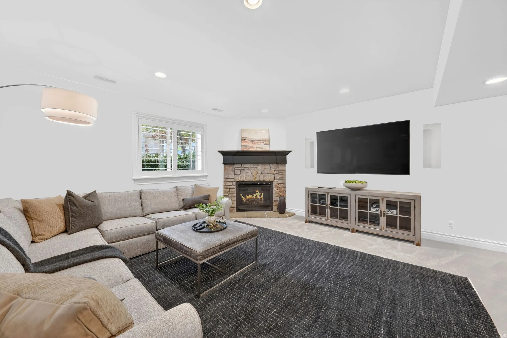 Living area featuring a fireplace, light colored carpet, and recessed lighting