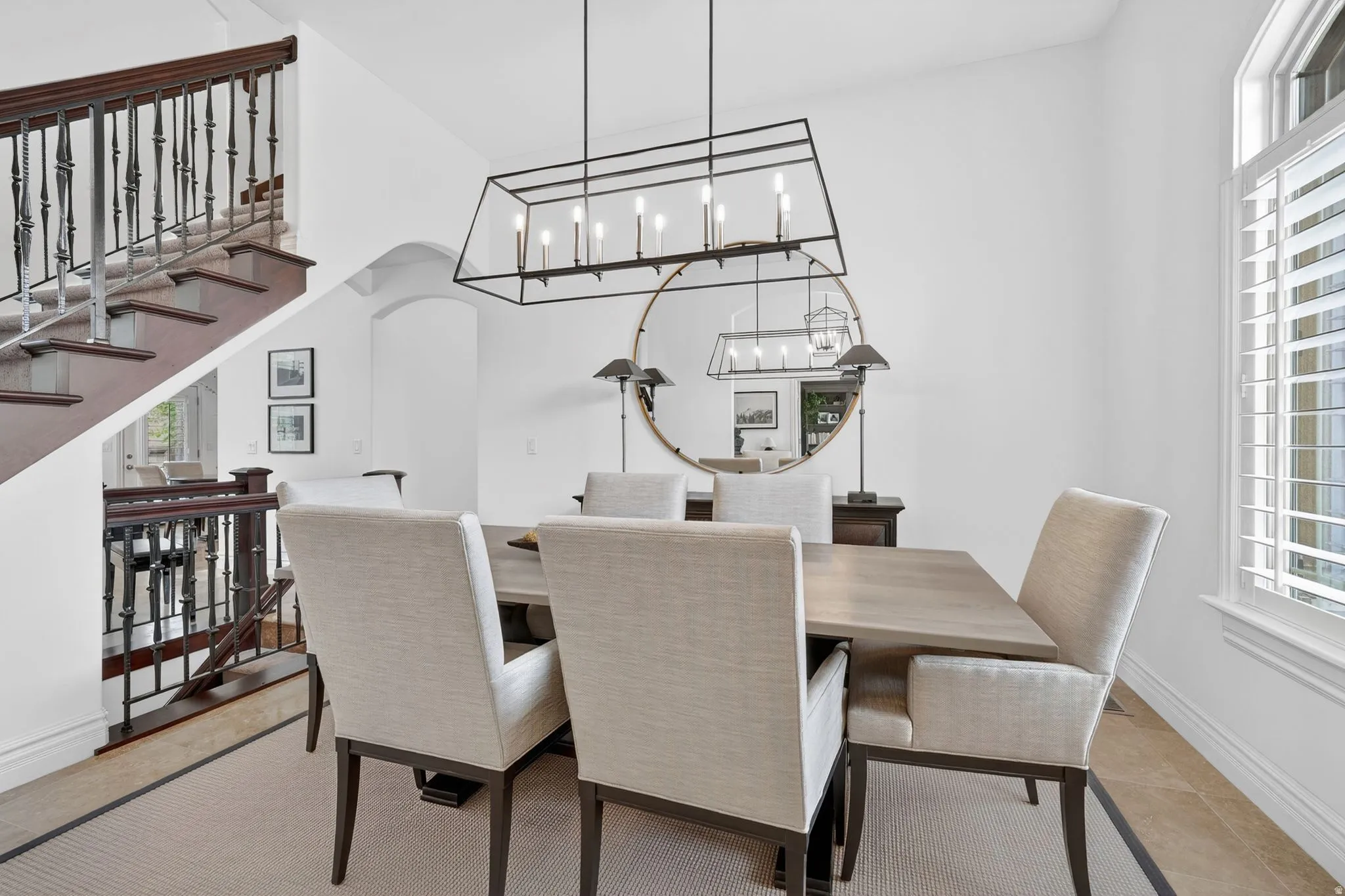 Dining room featuring a chandelier, arched walkways, and light tile patterned flooring