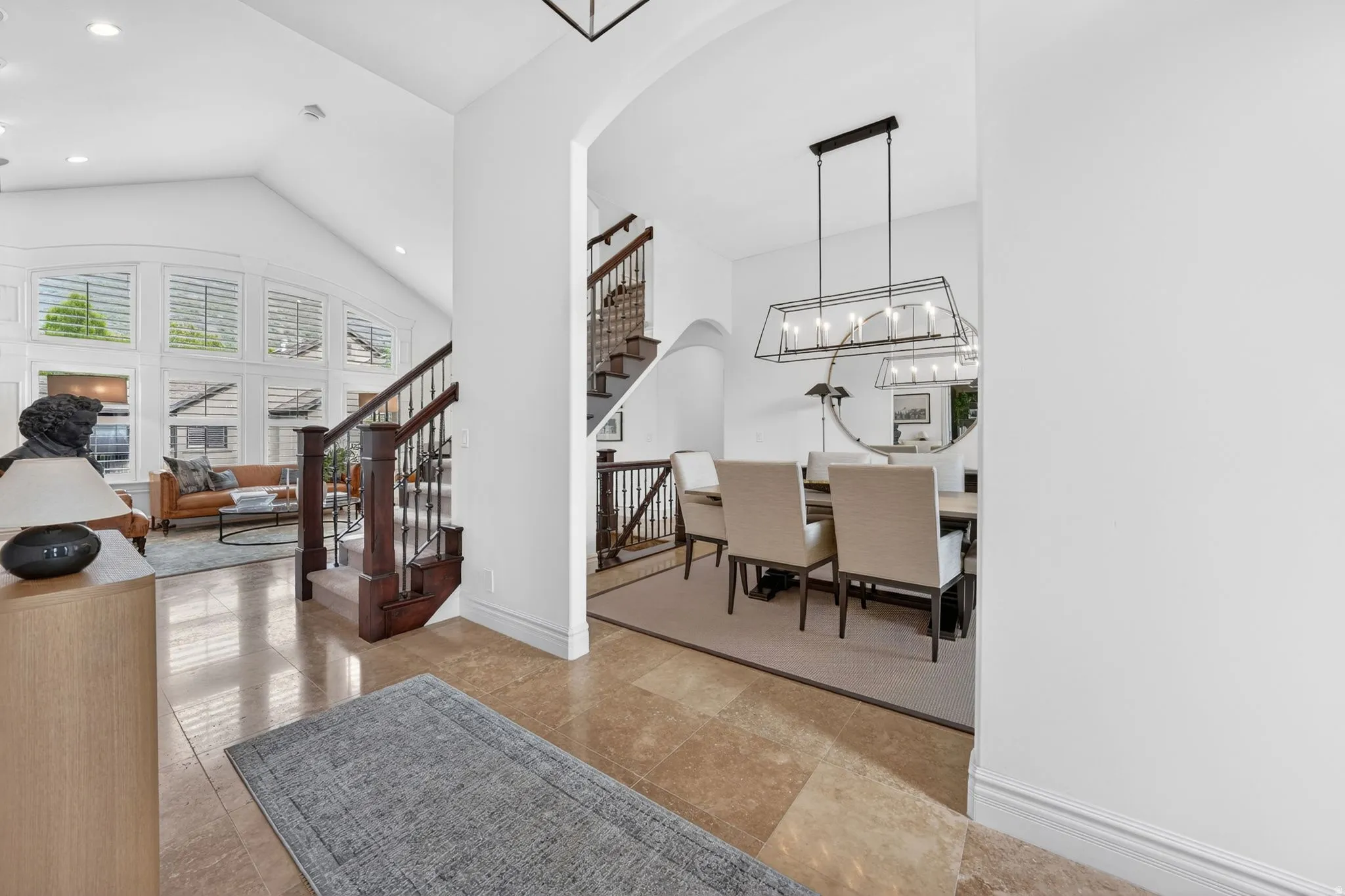 Entrance foyer with arched walkways, vaulted ceiling, and suspended lighting