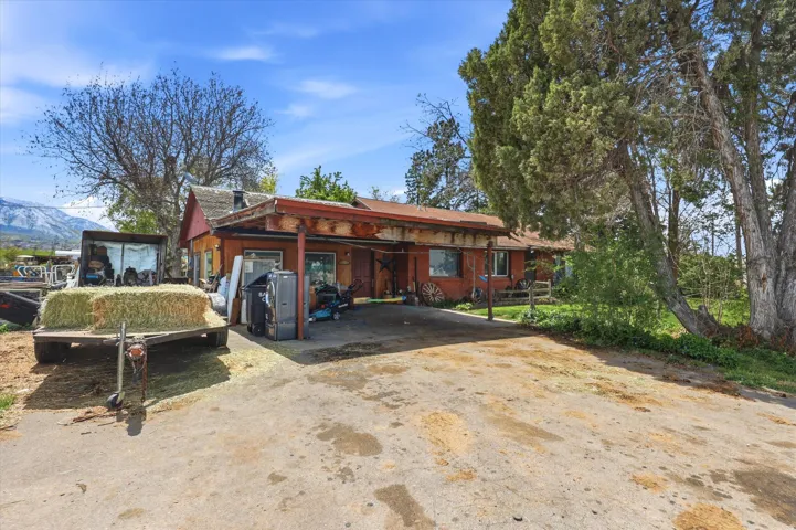 View of front facade with a carport and dirt driveway