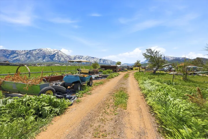 View of dirt / gravel road with a mountain view and a rural view