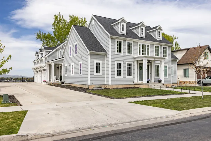 View of front of house featuring driveway, a shingled roof, a front lawn, and an attached garage