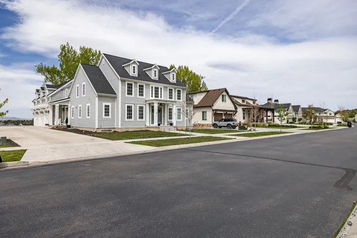 View of front of property featuring a residential view, concrete driveway, and a garage