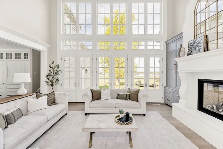 Living room featuring a glass covered fireplace, a high ceiling, french doors, and wood finished floors