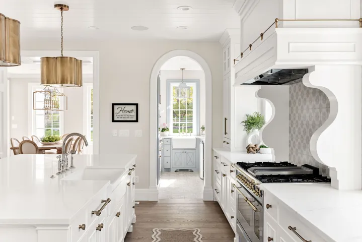 Kitchen featuring white cabinets, light stone counters, dark wood-style flooring, and range with gas cooktop