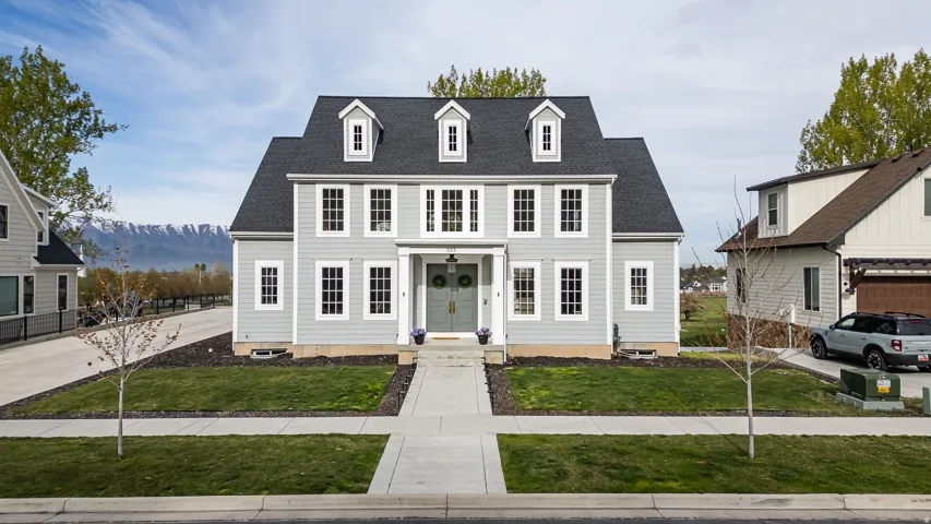 View of front of house featuring a shingled roof, a front lawn, and a mountain view