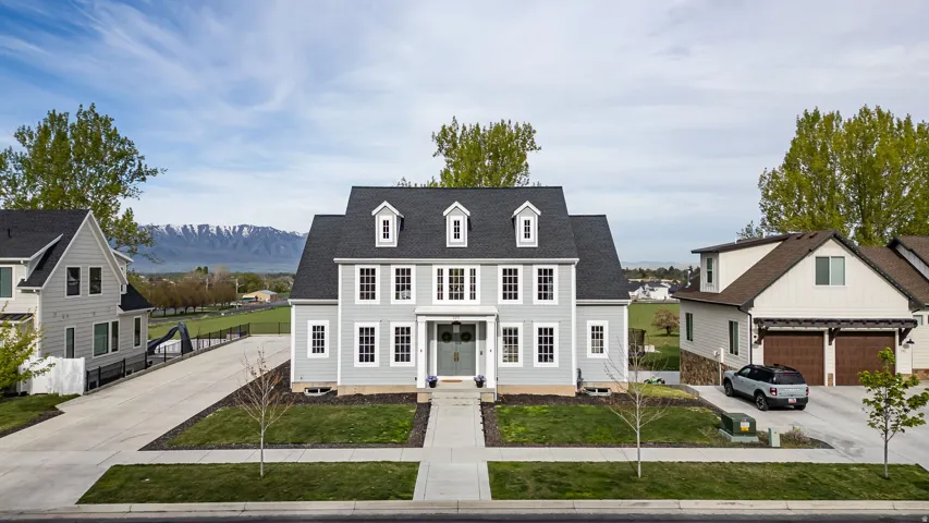 View of front of home with roof with shingles, a mountain view, and driveway