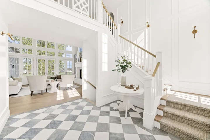 Staircase with a decorative wall, a high ceiling, and a fireplace