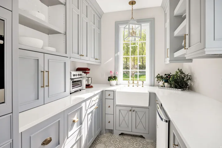 Dual tone kitchen featuring open shelves, light stone counters, hanging light fixtures, dishwasher, and two tone cabinetry