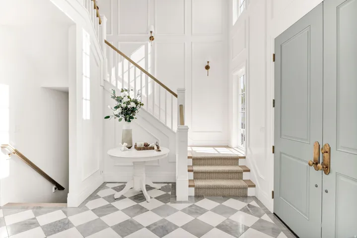 Staircase with a decorative wall, a high ceiling, and tile patterned floors