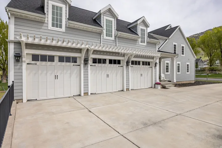 View of front of house featuring a shingled roof and driveway