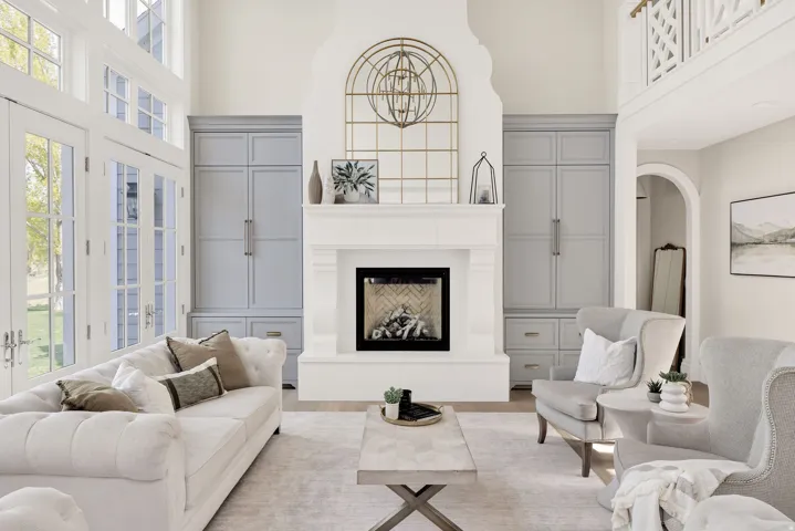 Living area with a fireplace with raised hearth, arched walkways, a high ceiling, and wood finished floors