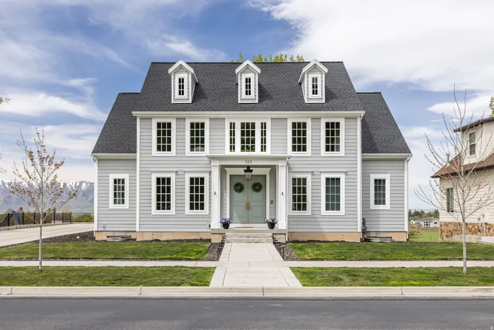 Colonial house with a shingled roof and a front yard