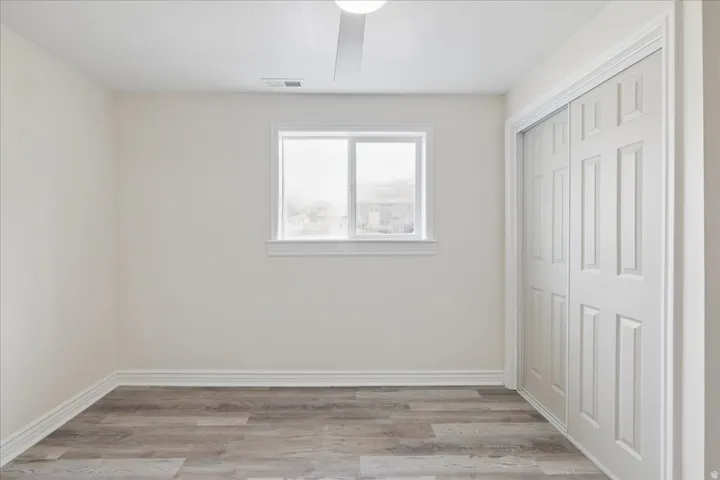Unfurnished bedroom featuring light wood-type flooring, a closet, and ceiling fan