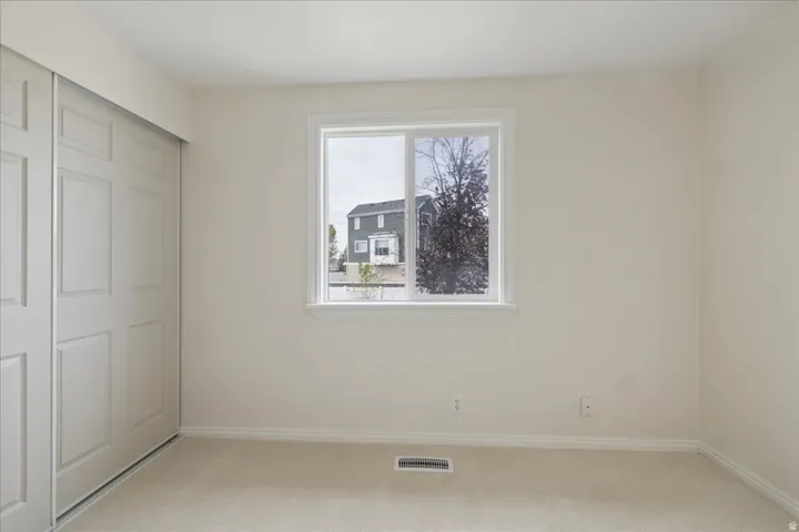 Unfurnished bedroom with a closet and light carpet
