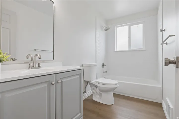 Bathroom featuring vanity, shower / washtub combination, and light wood-type flooring