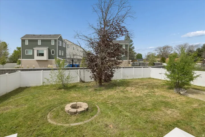 Fenced backyard with a fire pit and a residential view