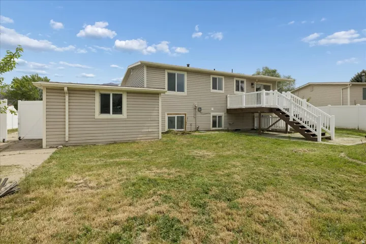 Back of property featuring stairway and a wooden deck