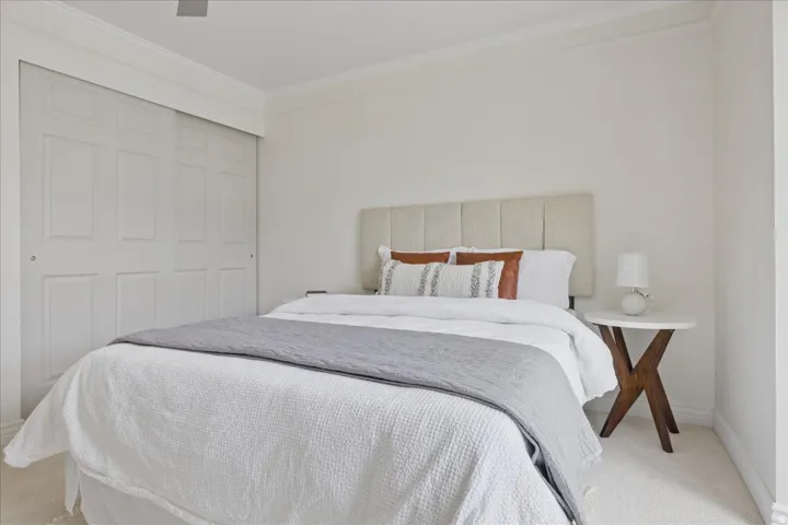 Carpeted bedroom with crown molding and a closet