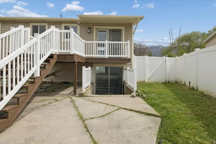 Rear view of property with a gate, a deck with mountain view, and a fenced backyard