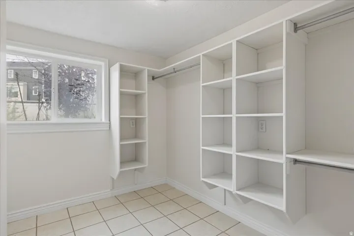 Walk in closet with light tile patterned flooring