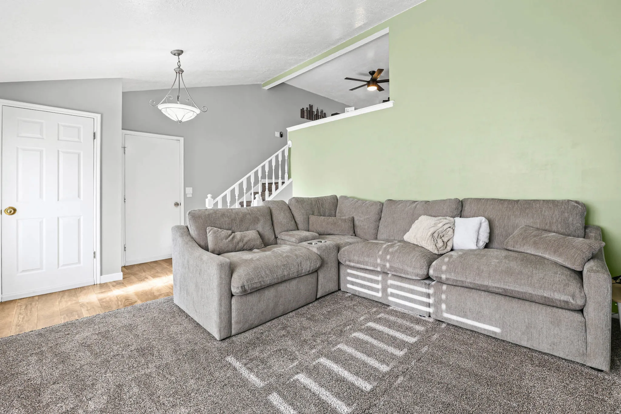 Living room featuring a ceiling fan and stairway