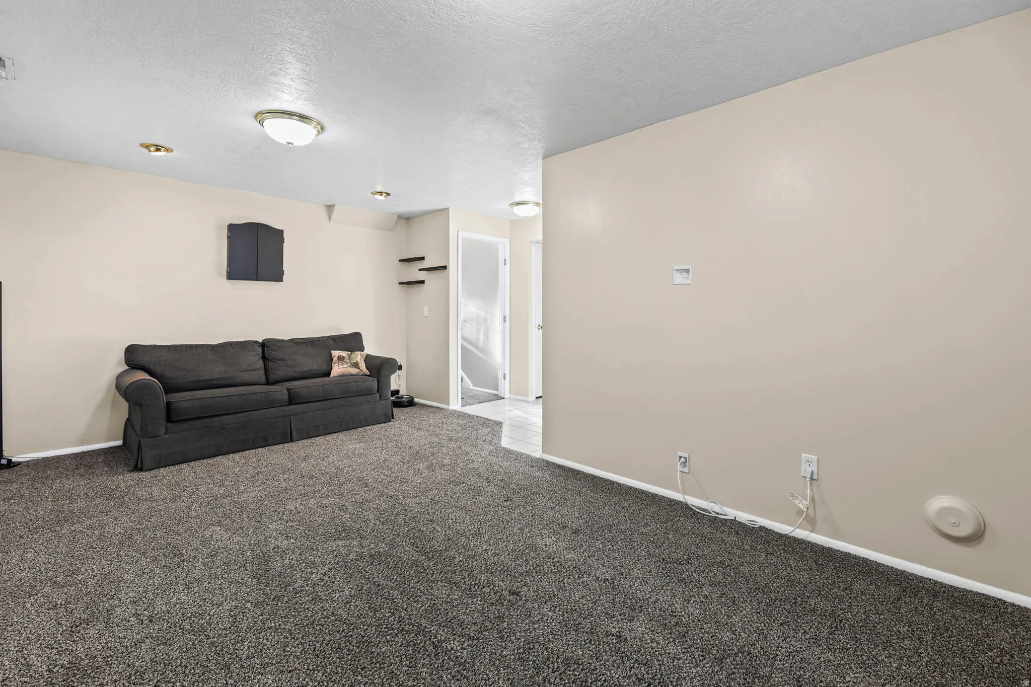 Living area featuring a textured ceiling and light colored carpet