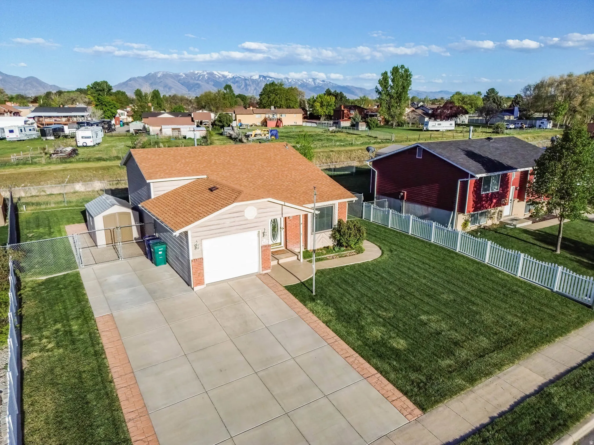 View of front facade featuring driveway, an attached garage, a residential view, and a mountain view