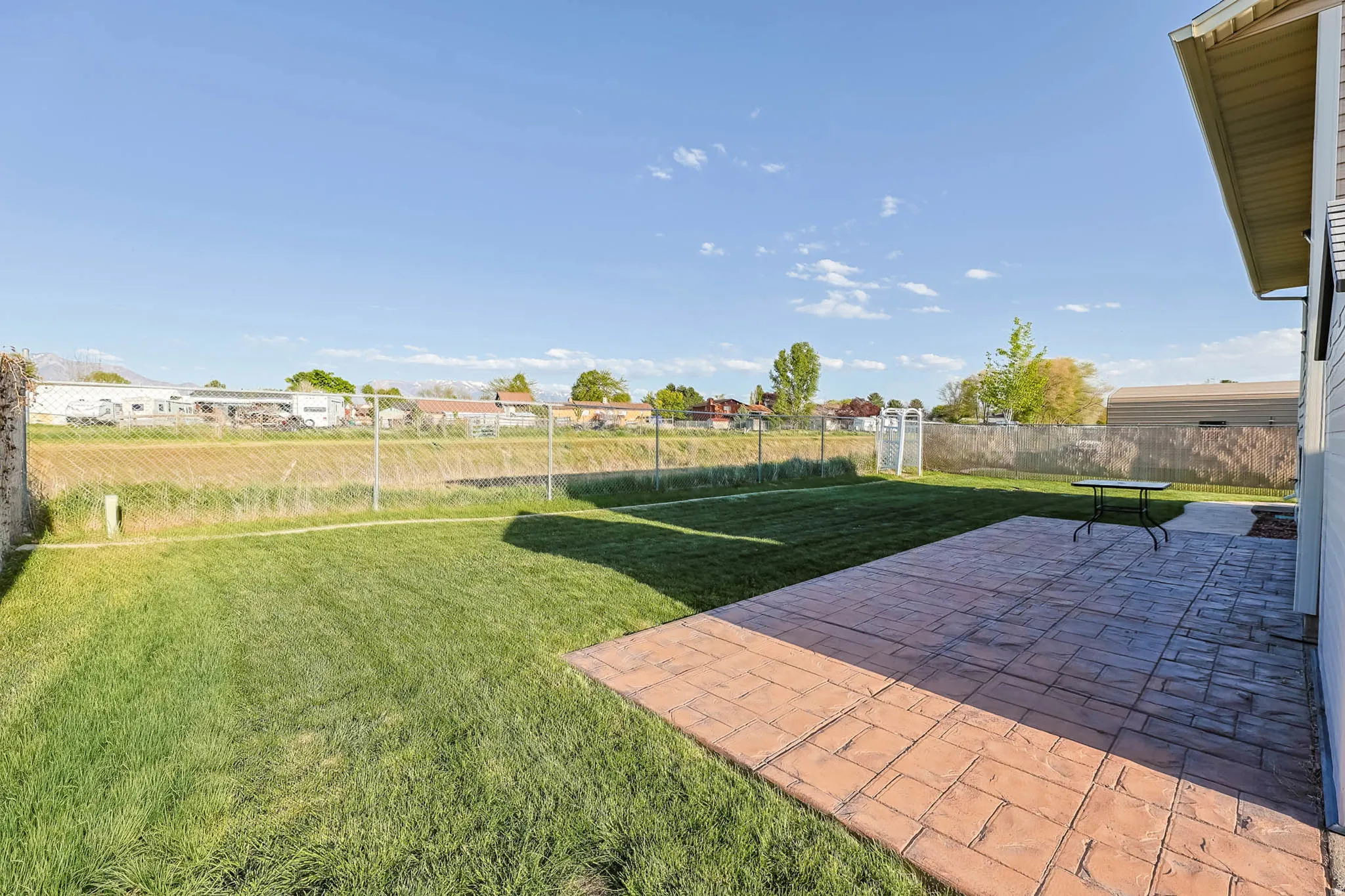 Fenced backyard featuring a patio area and a residential view