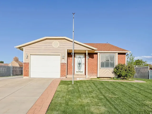 View of front of home featuring concrete driveway, a garage, and brick siding