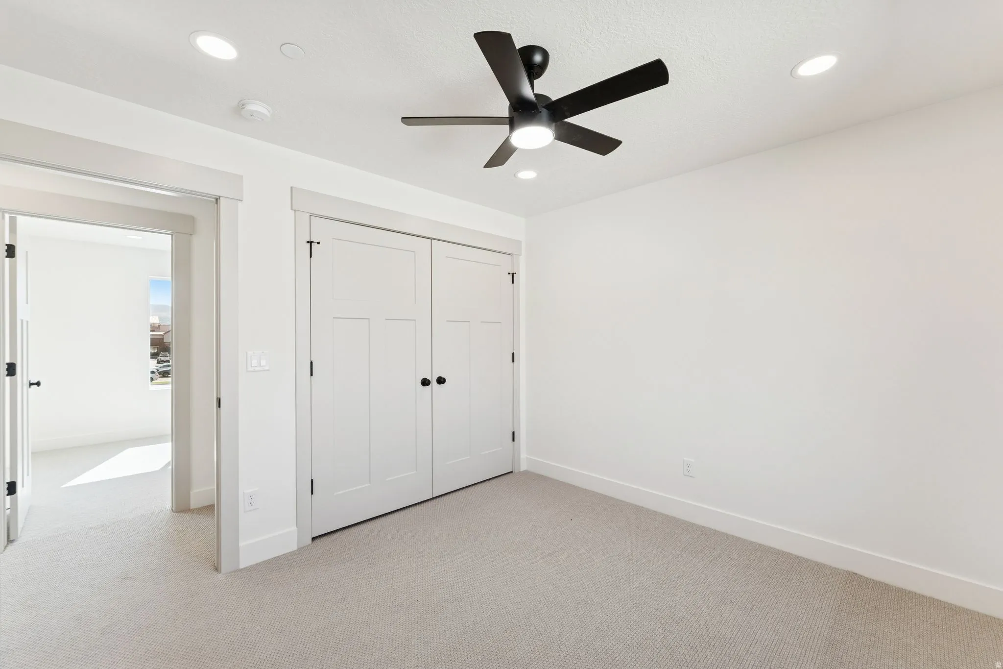 Unfurnished bedroom featuring light carpet, a closet, a ceiling fan, and recessed lighting