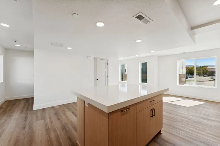 Kitchen with a center island, light wood-style flooring, recessed lighting, a textured ceiling, and wood finish cabinetry